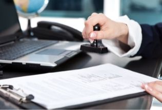 Birth certificate attestation process – document being stamped for official validation.