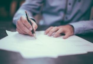 Person signing documents related to birth certificate attestation – NRIWAY company services.